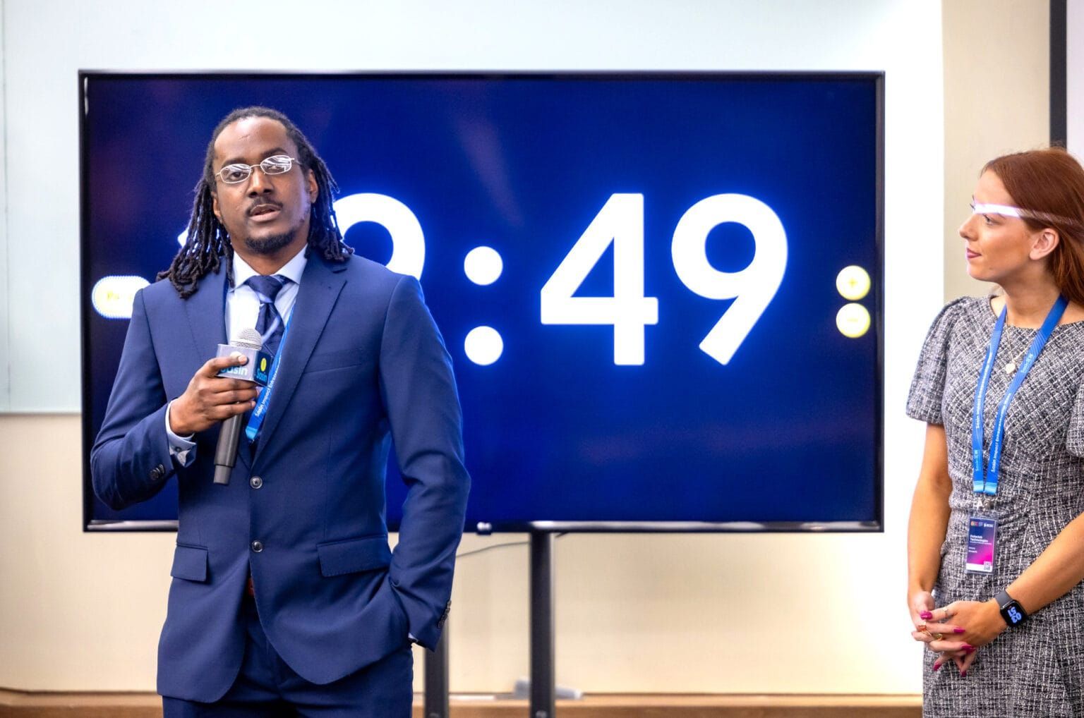 Henry Palfrey, Ph.D., speaks during the playoff round of the competition as Victoria Bourgeois, MBA, stands by.