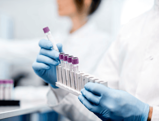 Person in a lab holding test tubes