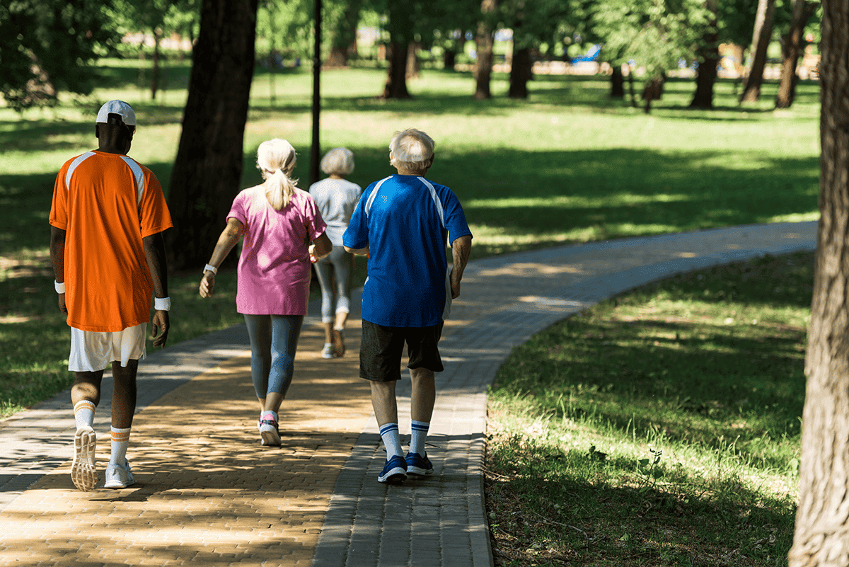 A group of people walk in a park.