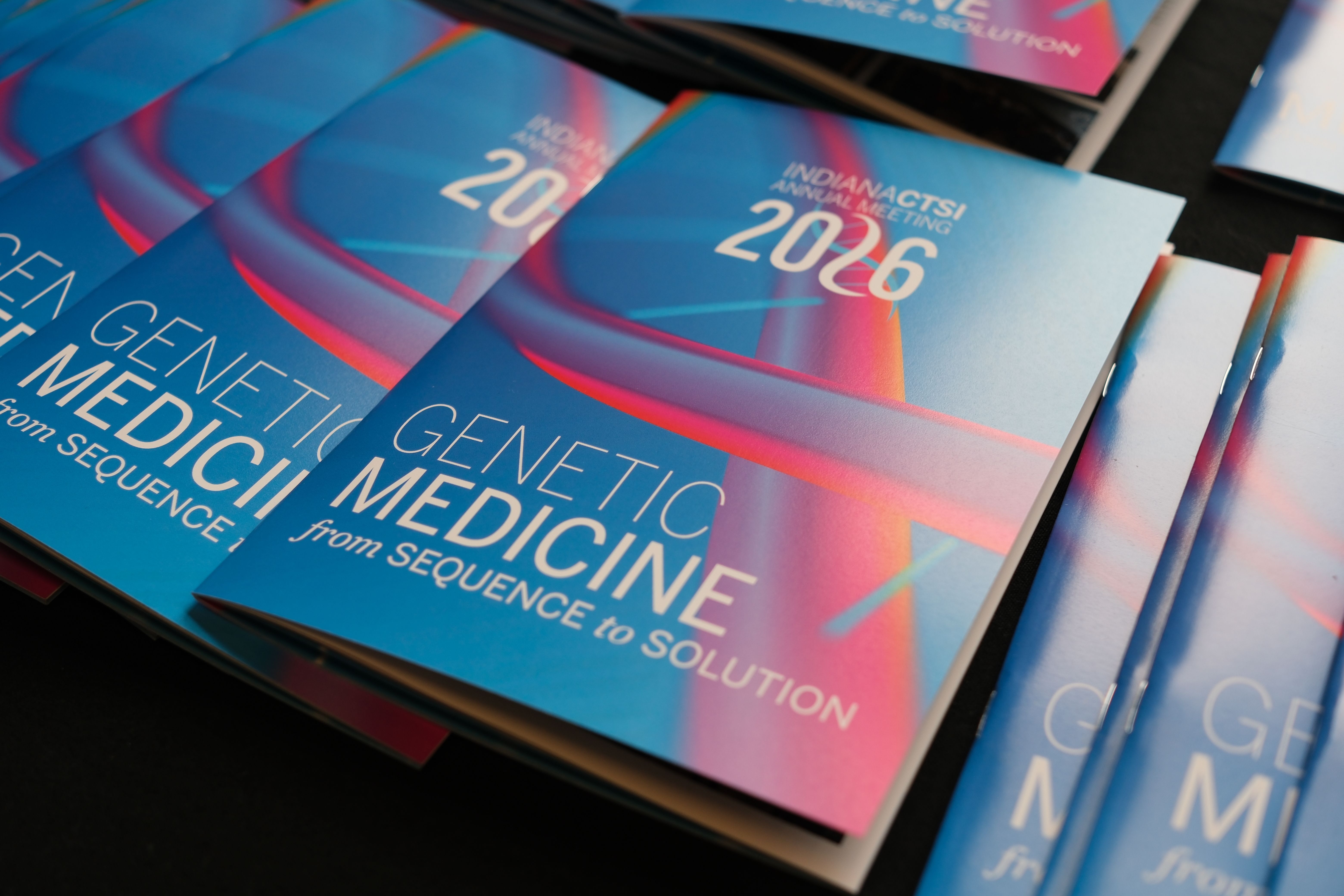 2026 Annual Meeting programs laid out on a table. Program reads "Indiana CTSI Annual Meeting 2026. Genetic Medicine: from sequence to solution"